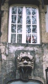 Der Legende nach ließ Anno über den Türen der Häuser der Aufrührer von 1074 Schandmasken, sogenannte 'Grinköpfe', anbringen, heute noch zu sehen wie hier am Gasthaus St. Peter am Heumarkt; tatsächlich sind dies als Häuserschmuck verkleidete Flaschenzüge