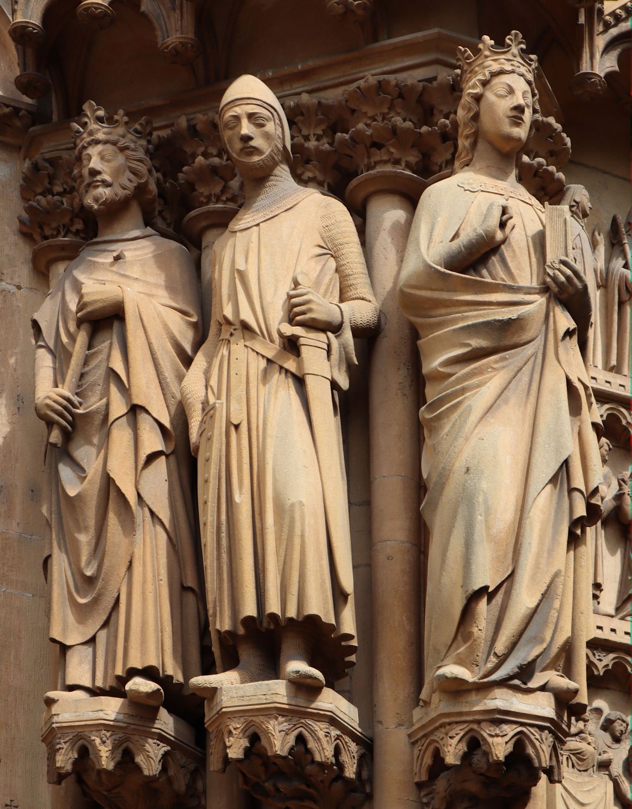 Auguste Dujardin: Hildegard (rechts) mit Livarius (Mitte) und Sigibert III. von Austrasien (links), Statuen, 1898, am Hauptportal der Kirche Ste-Ségolène in Metz