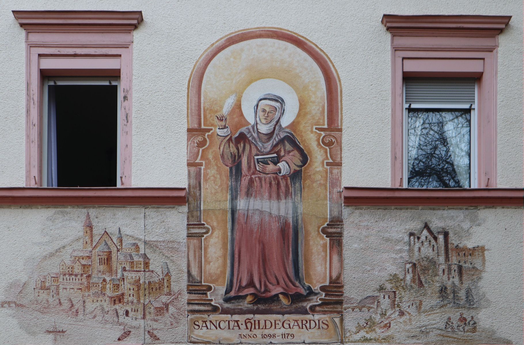 Wandmalerei: Hildegard mit ihren Klöstern Rupertusberg (links) und Eibingen (rechts), an einem Haus neben der Kirche St. Martin in Bingen