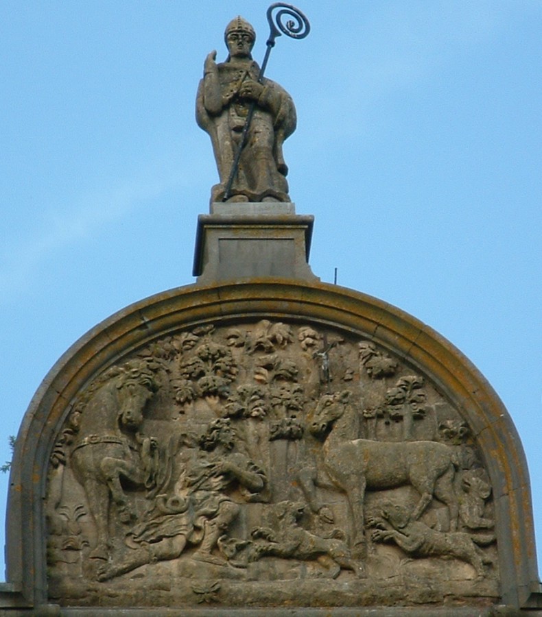 Statue und Jagdszene an der Fassade der Kirche in St-Hubert