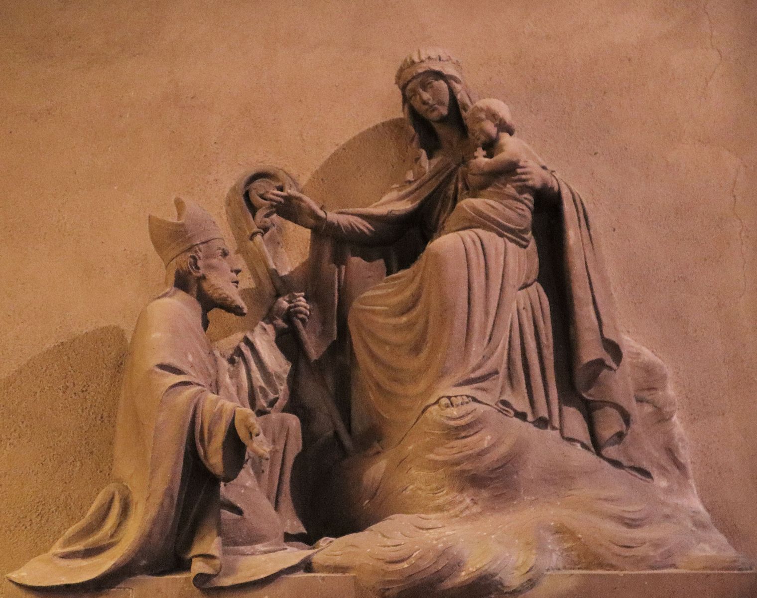 Relief: Leodegar vor Maria und dem Jesuskind, in der Leodegar geweihten Kirche in Guebwiller