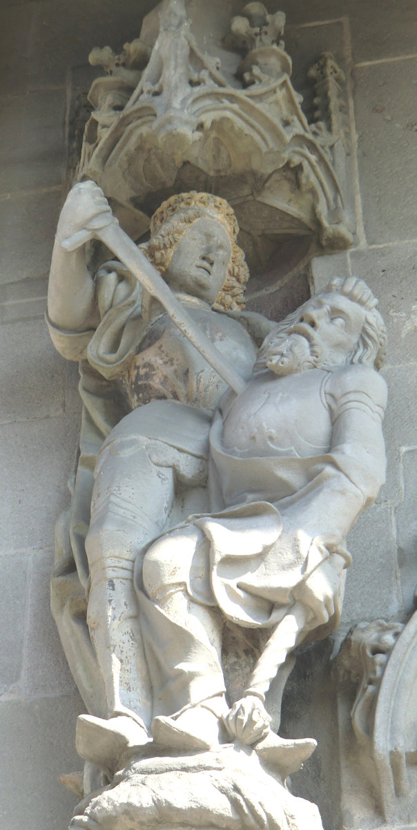 Skulptur: Oswald ersticht Cadwallon, den König von Gwynedd, um 1492, an der Kirche St. Oswald in Zug in der Schweiz