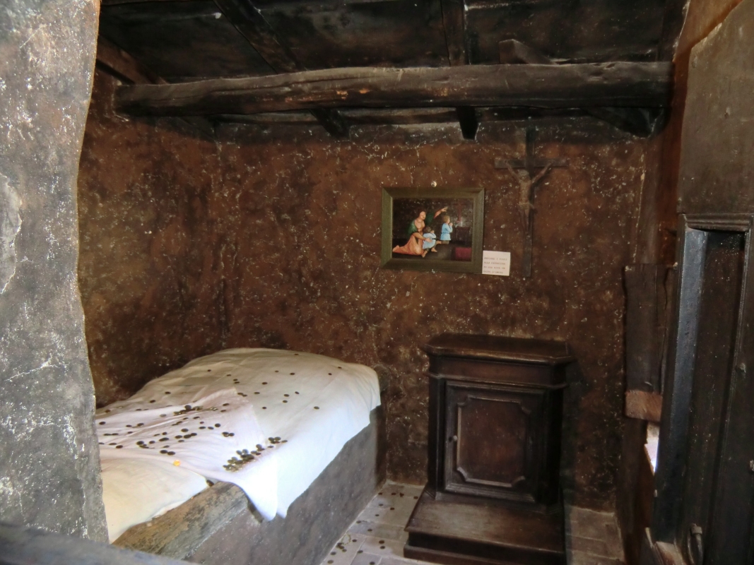 Schlafzimmer neben der Küche in Ritas Geburtshaus; das moderne Bild an der Wand zeigt, wie Rita ihre Kinder beten lehrte