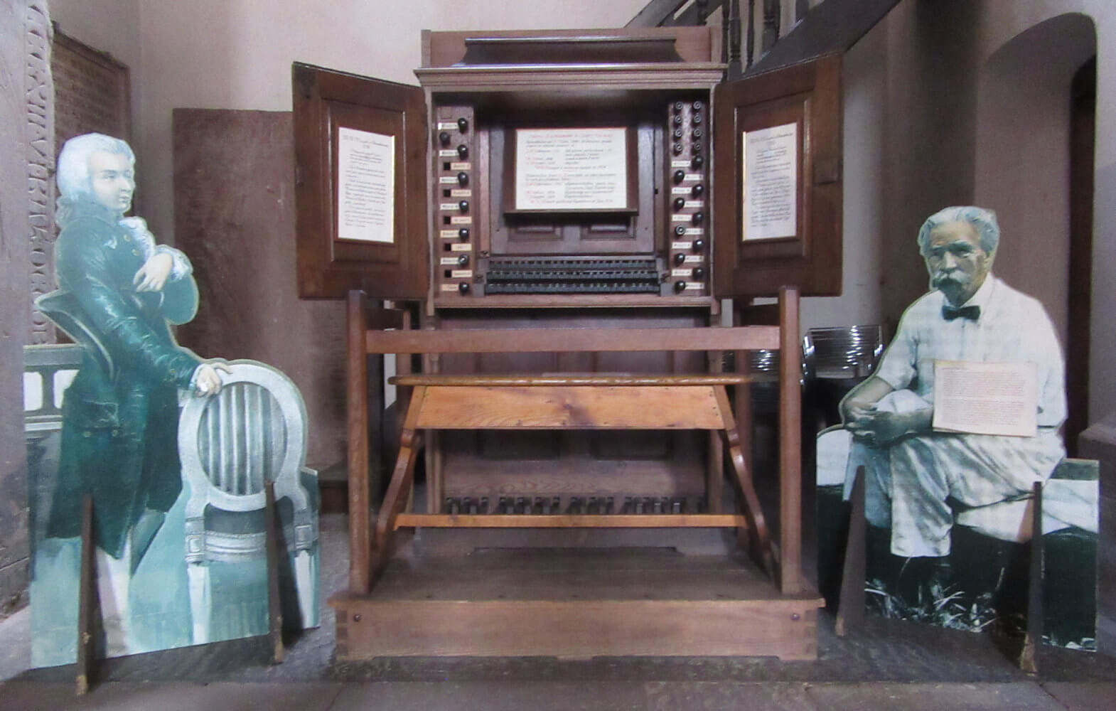 alter Spieltisch der Orgel in der Thomaskirche in Straßburg mit Darstellung von Johann Sebastian Bach (links) und Albert Schweitzer
