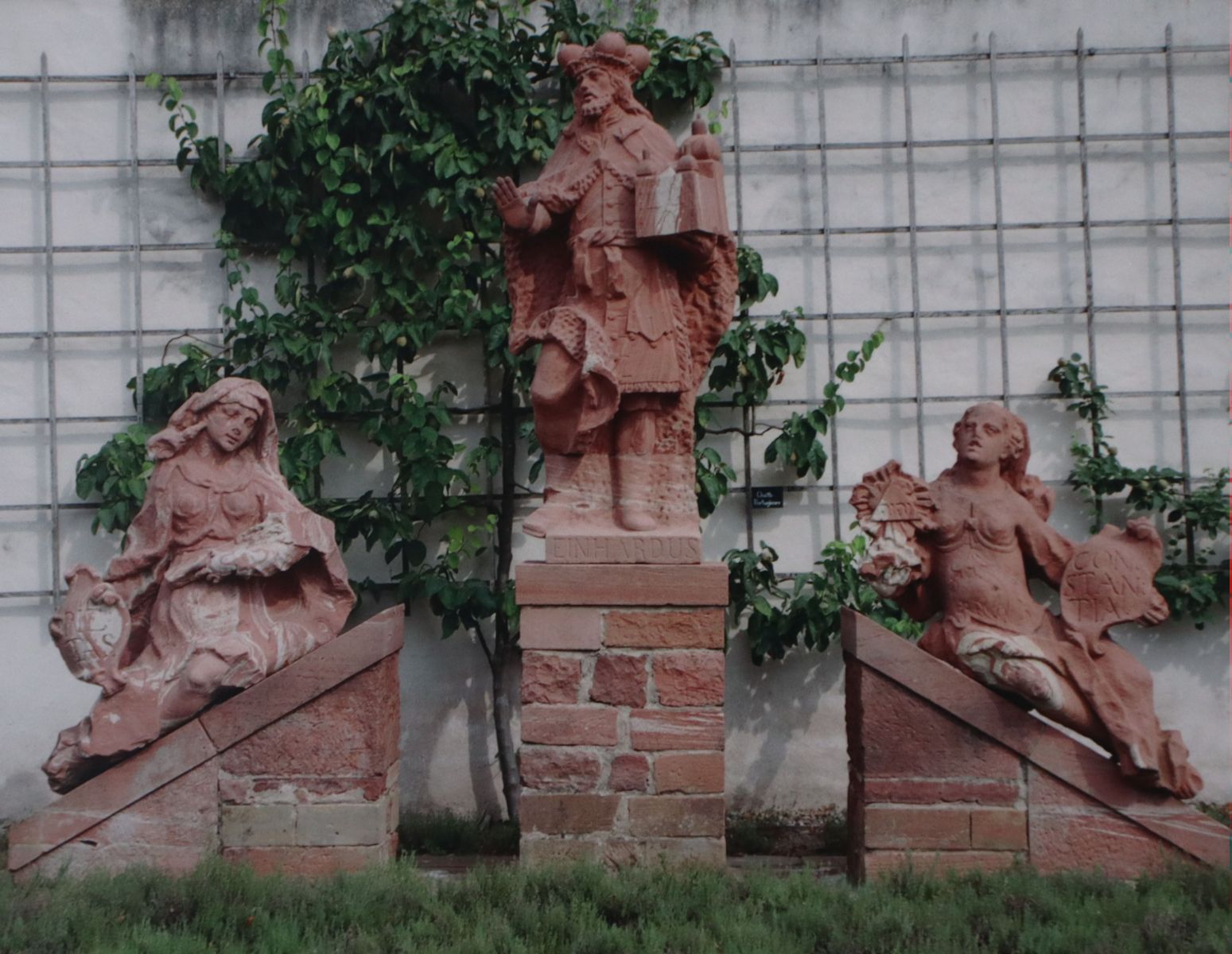 Klostergründer Einhard mit den Tugenden Frömmigkeit (links) und Standhaftigkeit, Statuen am ehemaligen Portal, jetzt im Konventgarten der Klosterkirche Seligenstadt