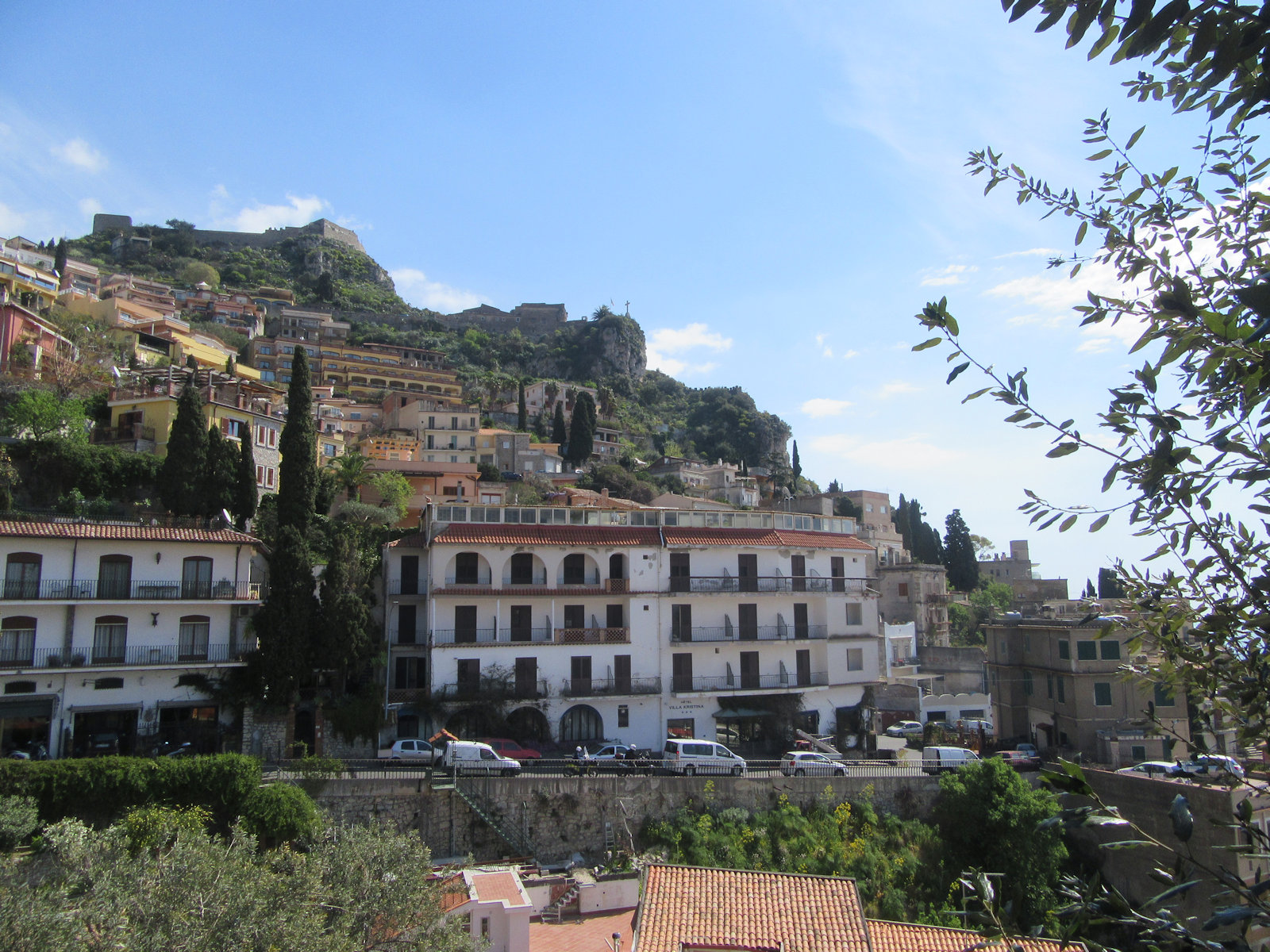 Blick auf das Kastell auf dem Monte Tauro oberhalb von Taormina, das Santuario Madonna della Rocca (mit dem Kreuz) und die heutigen südlichen Ausläufe der Stadt