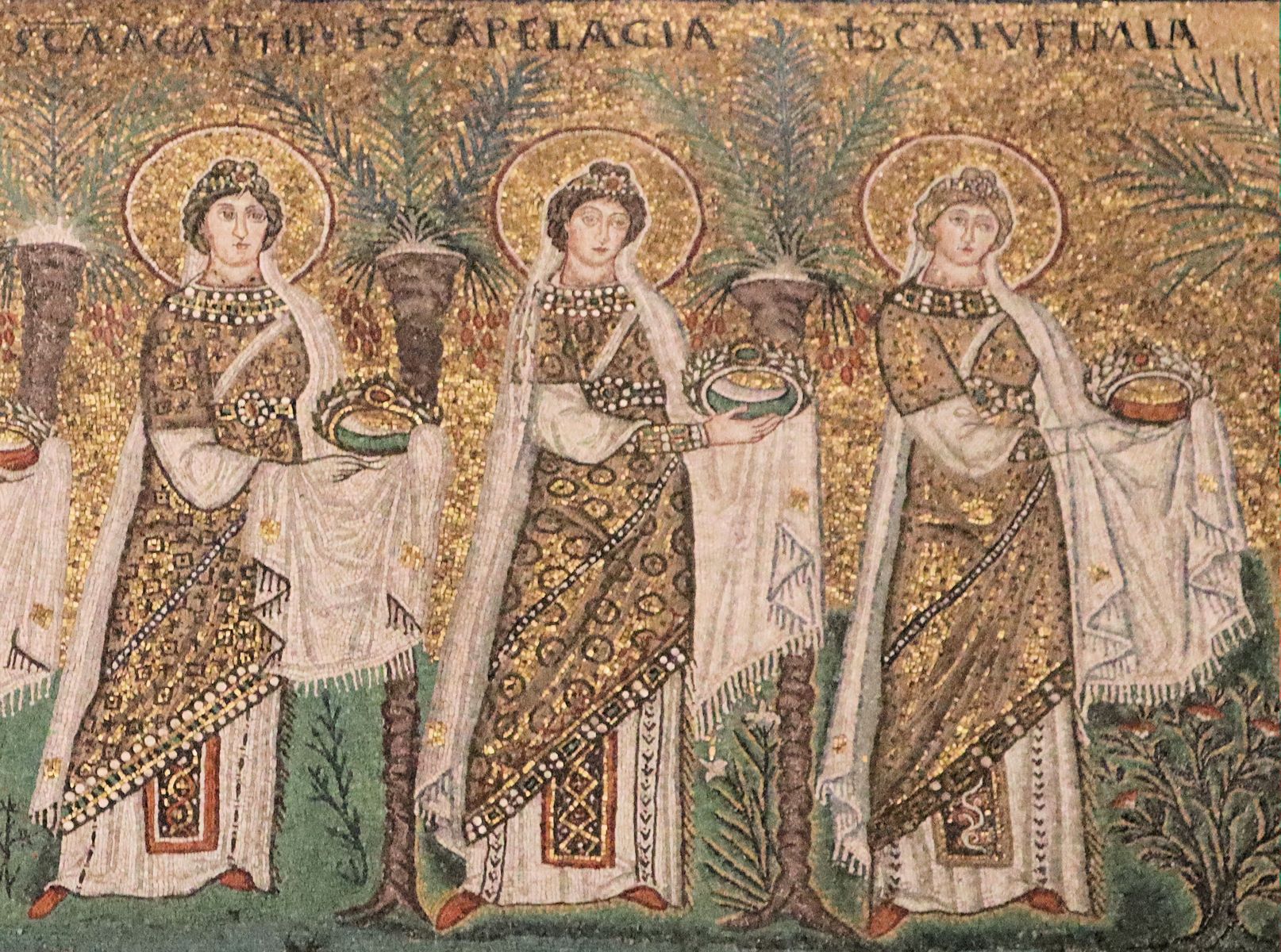 Detail aus dem Mosaik der „Jungfrauenprozession”: Euphemia (rechts), Pelagia von Tarsus (Mitte) und Agatha von Catania (links), 6. Jahrhundert, in der Basilika Sant'Apollinare Nuovo in Ravenna