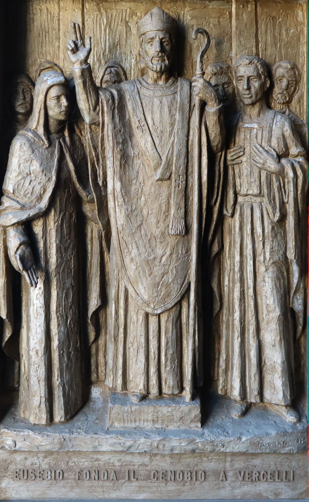 Eusebius als Gründer der Mönchsgemeinschaft an der Kathedrale in Mailand, Bronzerelief an der Tür der Pfarrkirche in Borgo Vercelli