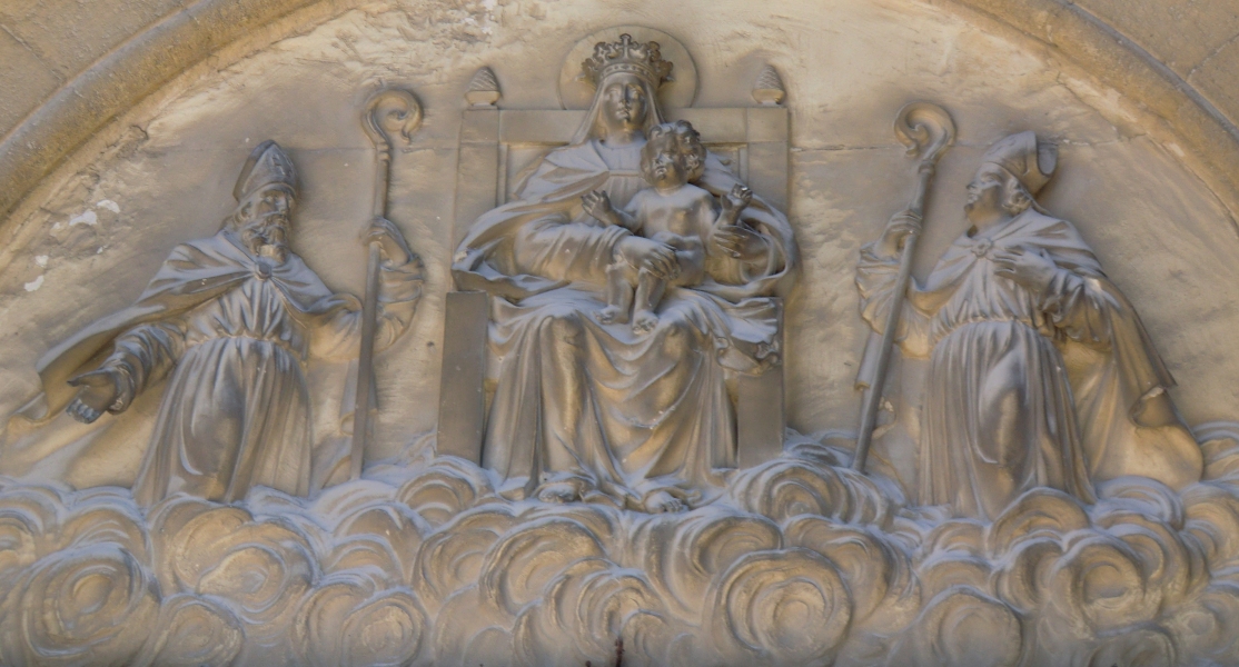 Relief: Maria und das Jesuskind mit Firminus von Uzès und Ferreolus, nach 1871, über dem Eingang der Kathedrale in Uzès
