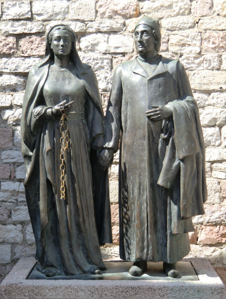 Roberto Joppolo: Franziskus' Eltern - die Mutter mit gesprengter Kette, der Vater mit Franziskus' abgelegten Kleidern, Bronzestatue, 1984, vor der Chiesa Nouva in Assisi