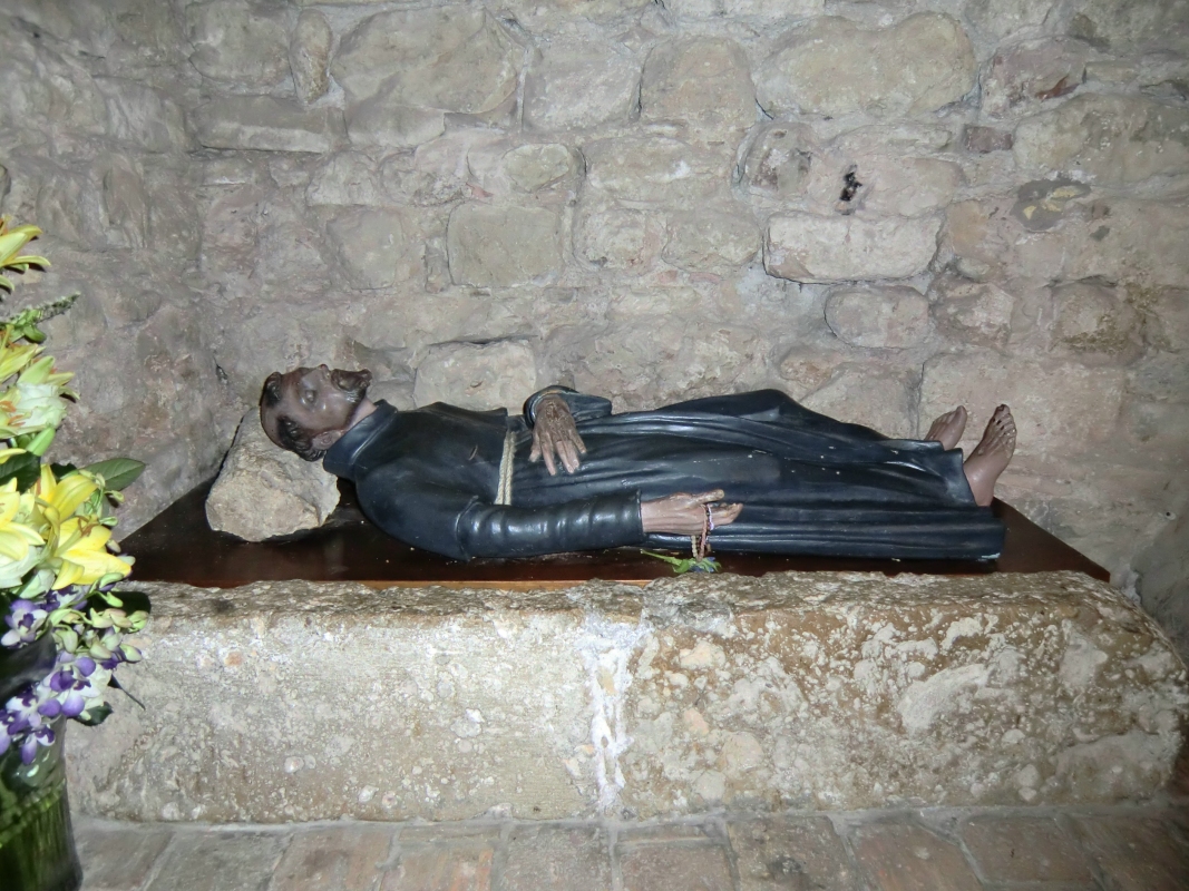 Franziskus, wie er auf Holz und mit einem Stein als Kopfkissen schlief; Liegefigur in der Kirche - Santuario Rivotorto