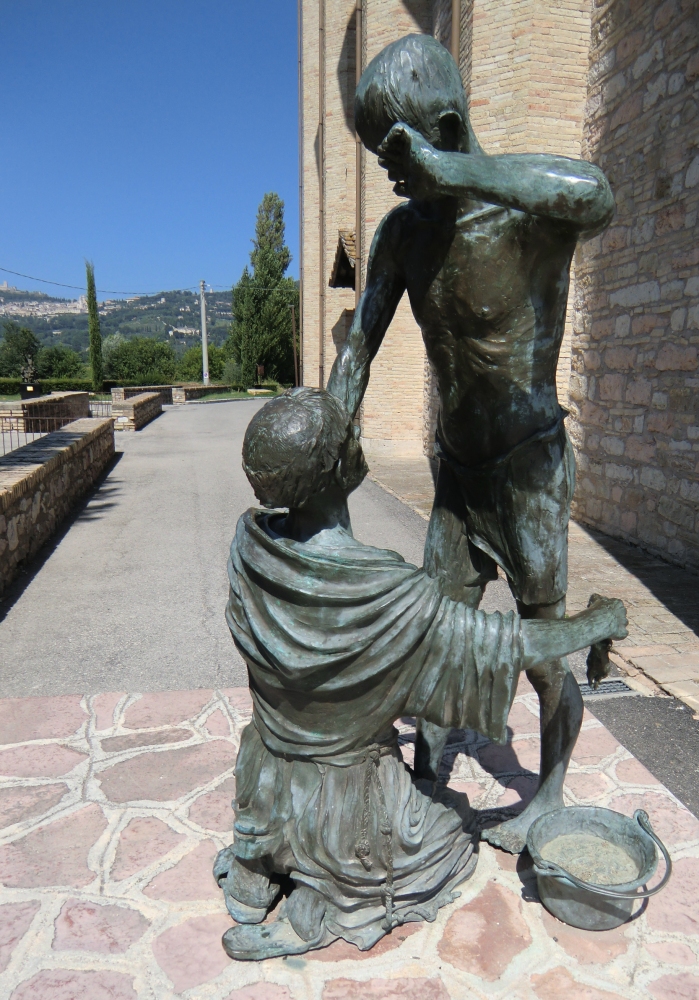 Fiorenzo Bacci: Franziskus pflegt und heilt einen Leprakranken, Bronzestatue, 2001, vor dem Santuario Rivotorto