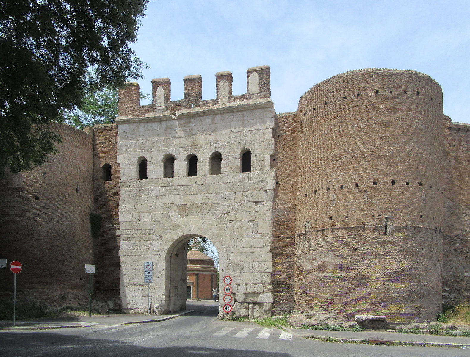Porta Latina in Rom; durch den Torbogen sieht man das auf einem älteren Bau 1509 wohl von Donato Bramante errichtete Oratorium, das der Überlieferung zufolge genau an der Stelle des Ölkessels steht