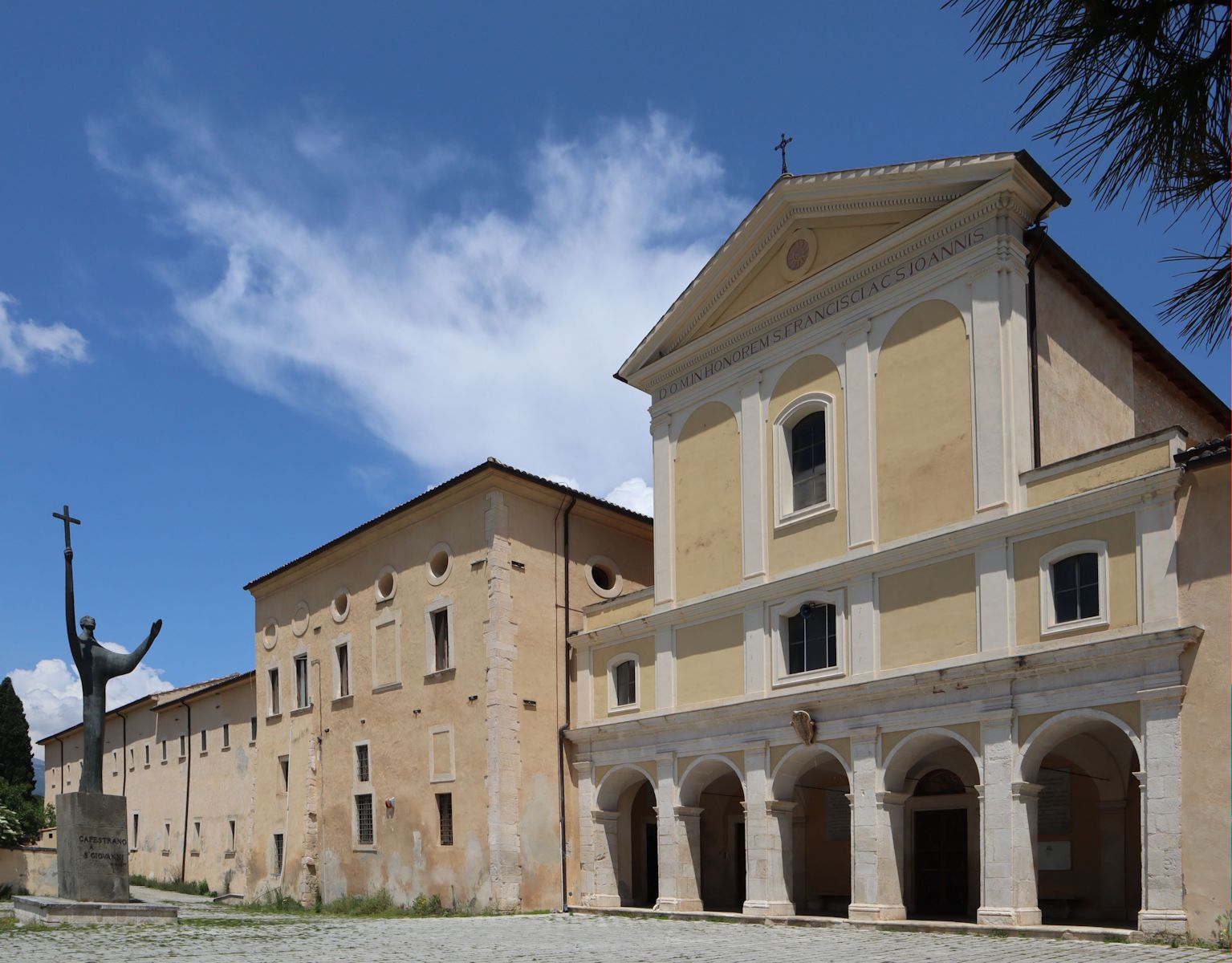 Franziskanerkloster n Capestrano, davor das 1977 aufgestellte Denkmal für Johannes