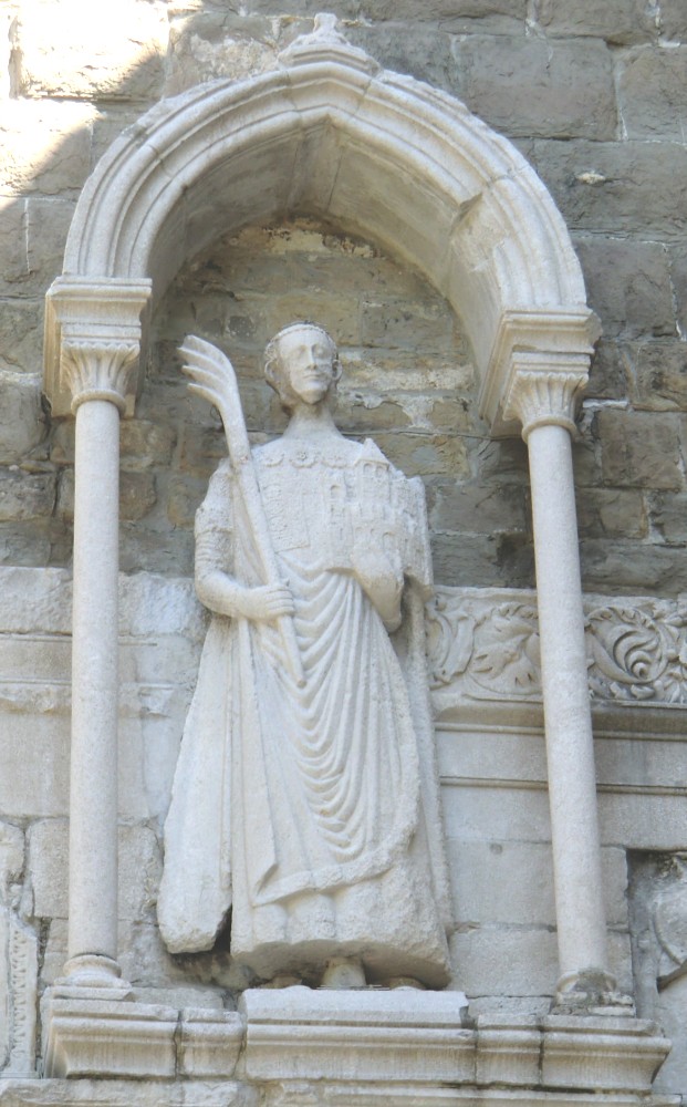 Justus mit Palme und Kirchenmodell in den Händen, Statue am am Glockenturm der Kathedrale San Giusto in Triest