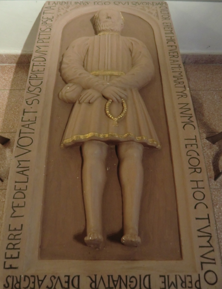 Deckplatte von Landelins Grab, 1624, in der Kirche in Münchweier, hier der Gipsabdruck der Steinplatte, die heute hinter dem Hochaltar steht und bis 1827 das Grab bedeckte. Inschrift: „Ich, Landelin, war einst Einsiedler, war hier Märtyrer, mich bedeckt dieses Grab. Durch mich gab Gott gnädig Kranken die Heilung, er wird auch deine Bitten empfangen.”