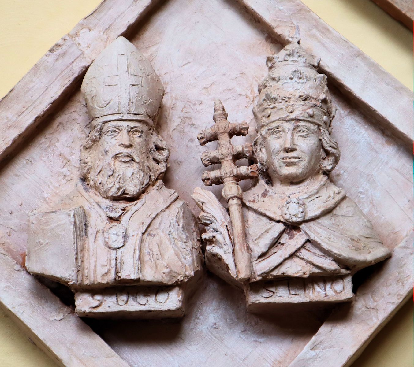 Roberto Chiti und Giorgio Finazzo: Linus (rechts) und Bischof Hugo von Volterra, Terracottarelief, Terracottarelief, 2019, im Kreuzgang der Kathedrale in Volterra