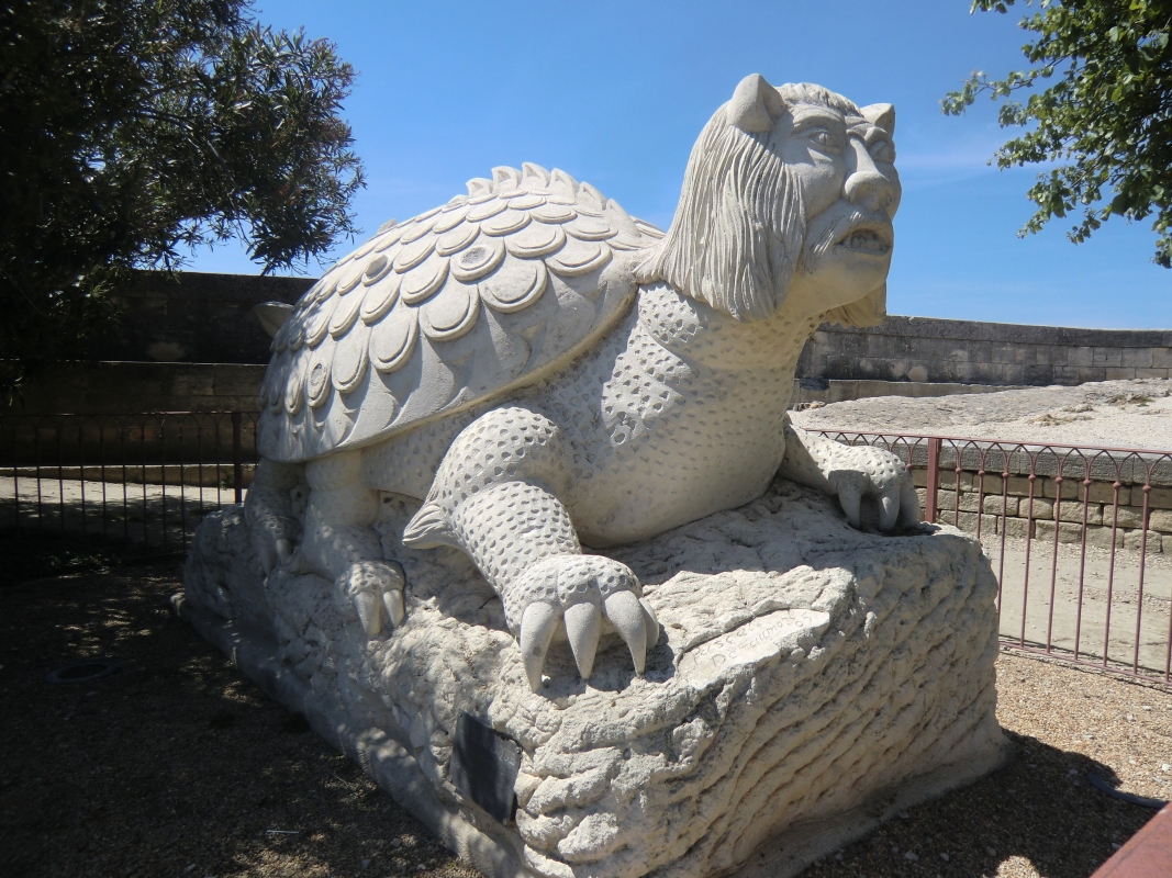 Statue: Tarasque, das schröckliche Ungeheuer, das Mensch und Tier im Rhônetal heimsuchte, Pascal Demaumont, errichtet auf Initiative eines <q>Ritters der Tarsaque</q> im Jahr 2005, gegenüber der Kirche Ste-Marthe in Tarascon