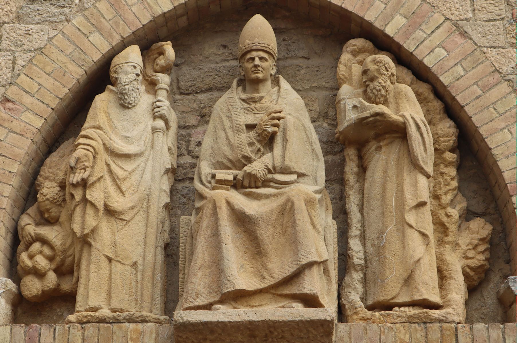 Relief Justus (Mitte), Clemens (links) und Oktavian (rechts), ann der Kathedrale in Volterra