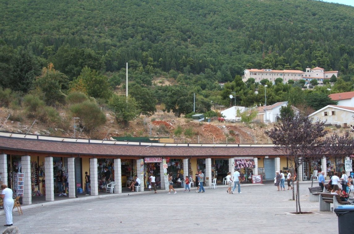 Ladengeschäfte im Pilgerzentrum, im Hintergrund das Kapuzinerkloster von San Giovanni Rotondo