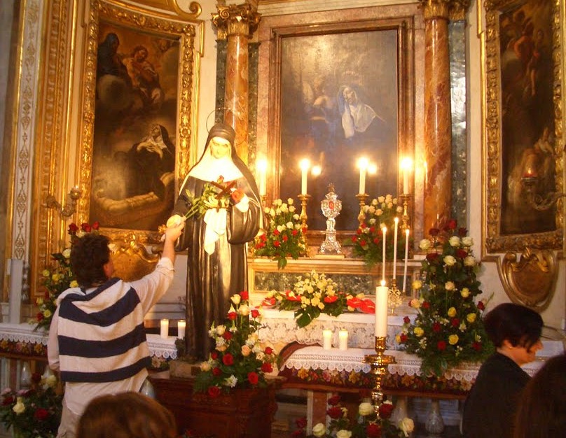 Rosensegnung in der Kirche S. Agostino in Rom: Die Rosen werden der Statue der Heiligen Rita kurz ans Herz gelegt
