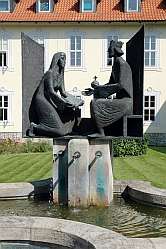 moderne Brunnenfigur: Hrotsvitha überreicht Kaiser Otto ihre Schriften, an der ehemaligen Abtei in Gandersheim