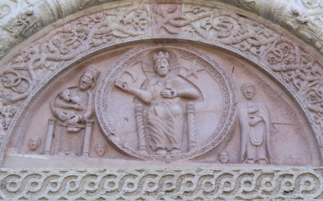 Christus auf dem Thron mit Maria, die ihr Kind stillt (links), und Rufinus (rechts), Relief, 12. Jahrhundert, oberhalb des Hauptportals der Kathedrale San Rufino in Assisi