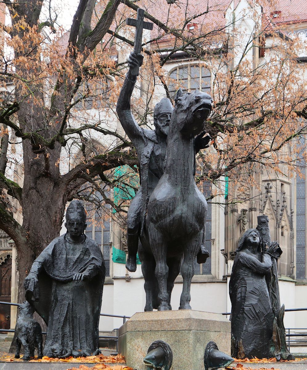 Josef Henselmann: Simpert mit Wolf und Kind (links), Bischof Ulrich von Augsburg beim Kampf gegen die Ungarn (Mitte) und Afra, 1986, am Brunnen vor dem Dom in Augsburg