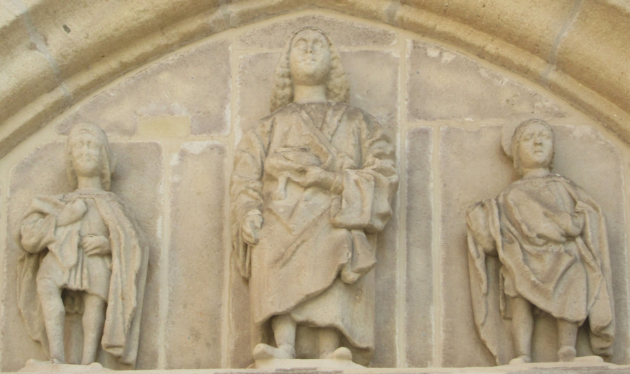 Sulpicius und Servilianus mit Vitus (Mitte), um 1475, Tympanon am Westportal der Stiftskirche St. Vitus in Ellwangen
