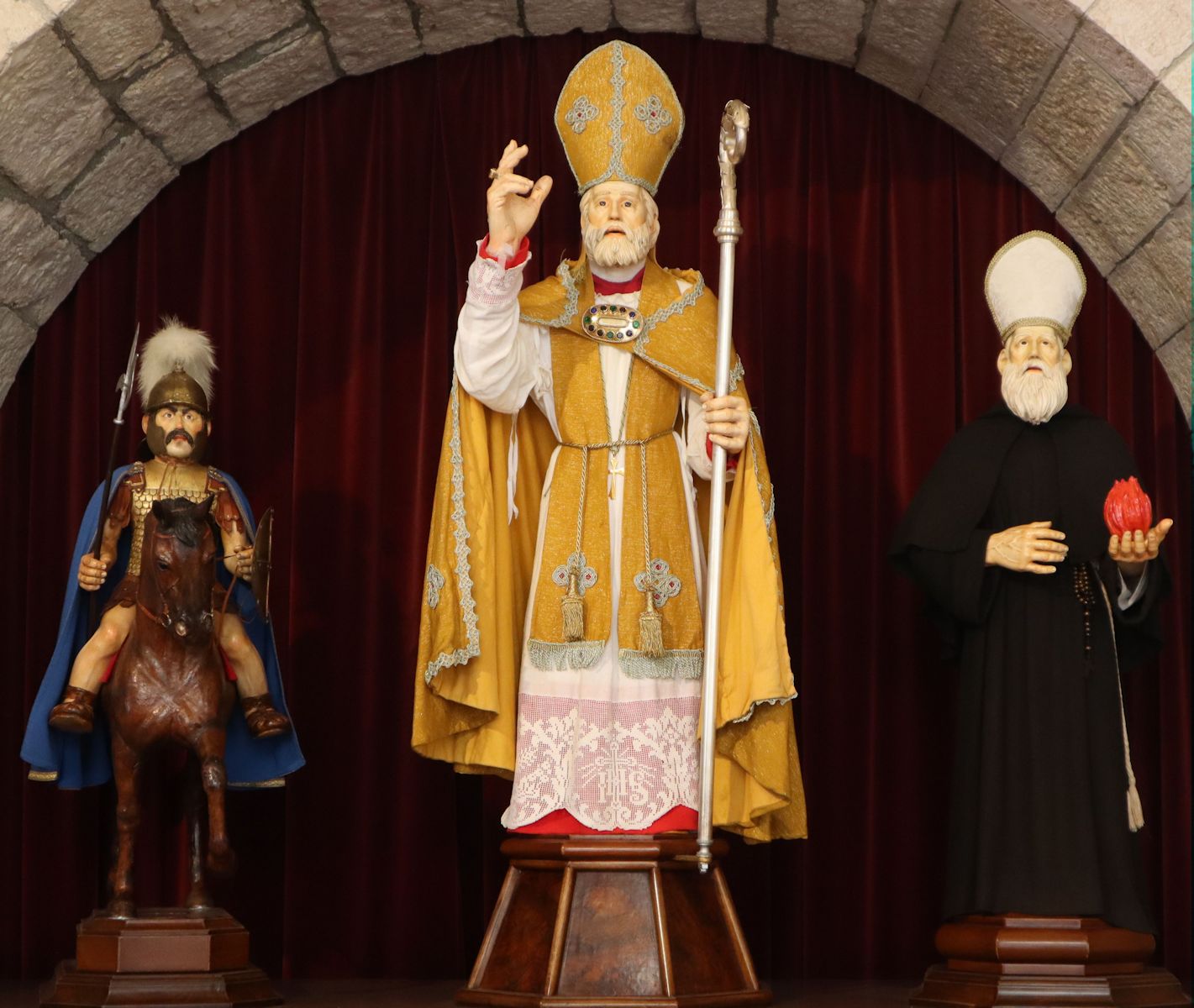 die Statuen, die beim jährlichen Volksfest „Corsa dei Ceri” in Gubbio durch die Stadt getragen werden: Georg der Märtyrer, Ubald und  Antonius „der Große” (von links), in der Kirche San Francesco della Pace