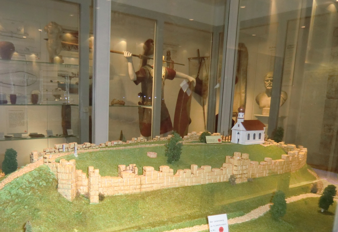 Rekonstruktion der direkt am Lech gelegenen römischen Befestigung und der Kapelle St. Lorenz in Epfach im 4. Jahrhundert, im Hintergrund römische Ausstellungsstücke